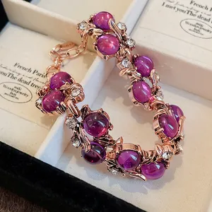 Dettaglio di bracciale foglia oro rosa con pietre magenta e strass trasparenti