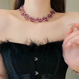 Elegante collana vintage con perle viola e design floreale indossata da modella