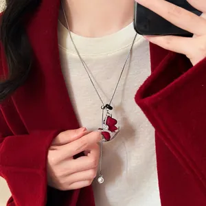 Elegant red flocked pendant sweater chain necklace shown as a detailed lifestyle shot