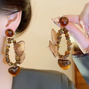 Gros plan de boucles d'oreilles vintage style Maillard avec cœur et fleurs