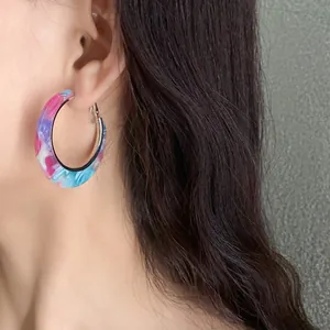 Detailed close-up view of colorful marbled acetate hoop earring worn by an Asian model