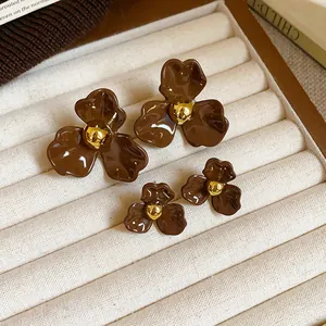 Vue détaillée de boucles d'oreilles en forme de fleurs brunes en deux tailles différentes