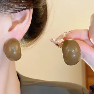 Gros plan détaillé sur des boucles d'oreilles clous géométriques marron vintage brillantes
