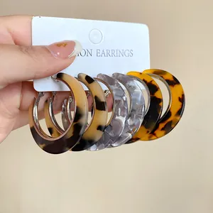 Detailed view of tortoiseshell acetate hoop earrings set with leopard print patterns