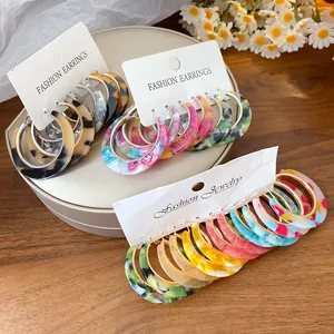Detailed view of colorful acetate hoop earrings with leopard and tie-dye patterns