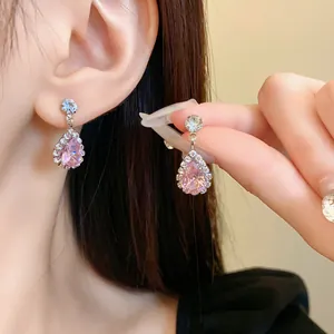 Dettaglio di orecchini di lusso in argento a goccia con zircone rosa e halo di diamanti