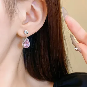 Primo piano dettagliato di una modella che indossa eleganti orecchini a goccia in zircone rosa
