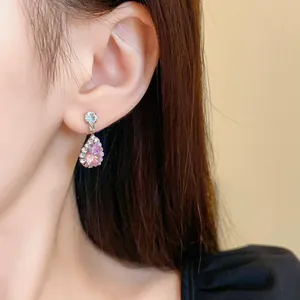 Primo piano dell'elegante orecchino pendente in zircone rosa a goccia sull'orecchio