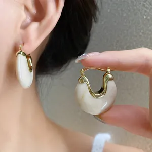Vintage gold-toned geometric hoop earrings with marbled white resin inlay detail