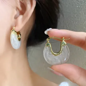 Detailed view of vintage resin geometric hoop earrings with elegant white marbled texture