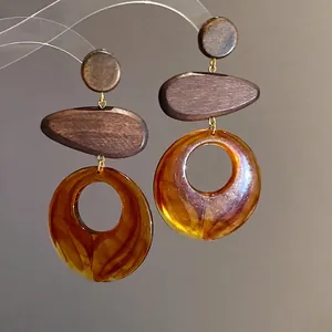 Elegant geometric dangle earrings featuring natural wood and amber resin elements