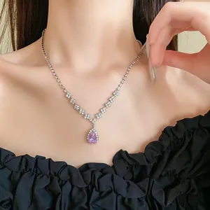 Primo piano dettagliato di una collana con ciondolo in zircone rosa a goccia e catena di strass