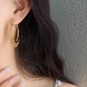 Close-up detail of a vintage acetate leopard print gold hoop earring worn by a model