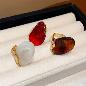 Adjustable fashion resin oval rings in red white and amber set in a jewelry box