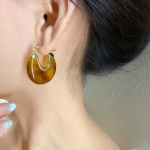 Detailed view of an elegant vintage amber resin geometric hoop earring on a model