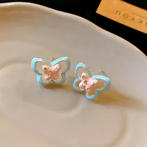 Close-up detail of blue and pink enamel butterfly stud earrings with rhinestones