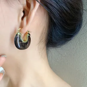 Detail shot of vintage resin geometric hoop earring with elegant black marble texture