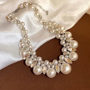 Elegante mehrsträngige Perlen- und Kristallkette auf weißem Seidenhintergrund
