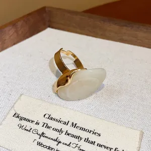 Detail macro view of an elegant gold ring with a smooth cream oval resin stone