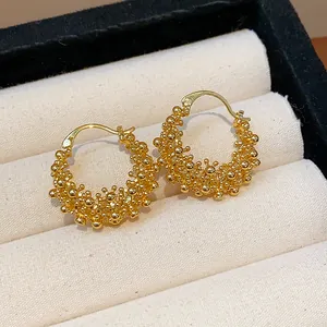 Detailed view of 18k gold plated hoop earrings with unique beaded texture