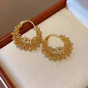 Detailed macro shot of 18k gold plated hollow textured hoop earrings in a jewelry box