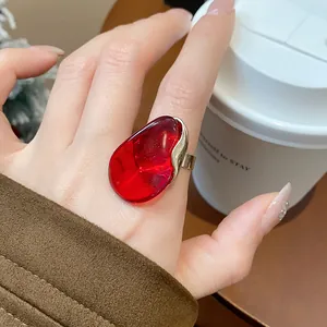Detailed close-up view of a trendy red resin oval open ring worn on a woman's index finger