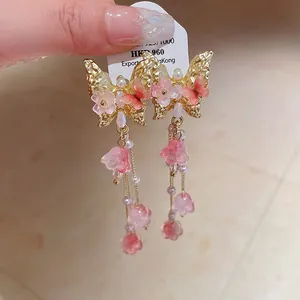 Detail shot of butterfly crystal tassel earrings featuring pink flowers and delicate pearls