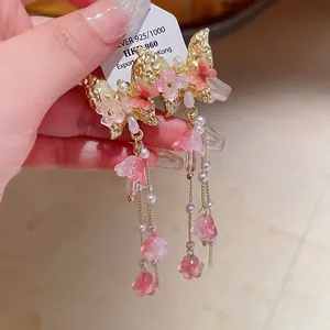 Detailed view of elegant pink butterfly crystal tassel earrings with gold finish.