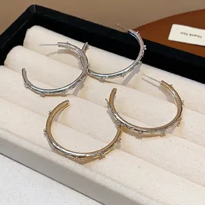 Minimalist silver and gold hoop earrings with zircon stones and cross engraved pattern