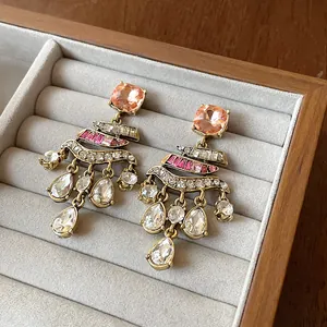 Detailed macro view of vintage rhinestone drop earrings in a grey jewelry tray