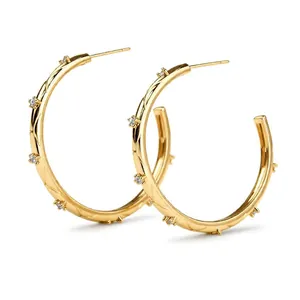 Elegant gold-plated hoop earrings featuring a quilted texture and sparkling cubic zirconia