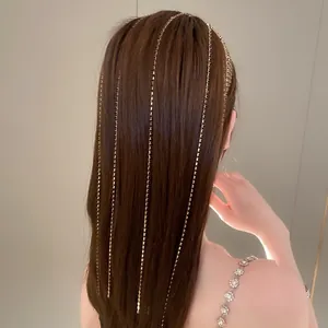 Dettaglio di un cerchietto multistrato con nappe dorate e strass scintillanti sui capelli