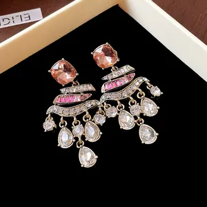 Detailed view of vintage-style drop earrings with sparkling rhinestones and teardrop tassels