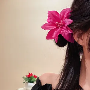 Close-up of a large fuchsia silk lily flower duckbill hair clip worn on a model's side hair