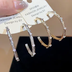 Close-up of zircon crisscross hoop earrings with S925 silver needles in gold and silver.