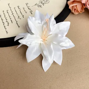 Close-up detail of a white silk lily hair clip showing delicate petal textures and style