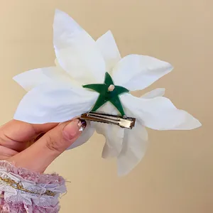 Back view of white lily flower hair clip showing metal duckbill attachment mechanism.