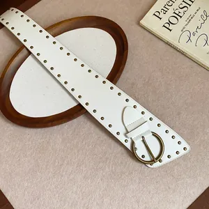 Detailed view of a white wide leather belt with bronze rivets and round buckle