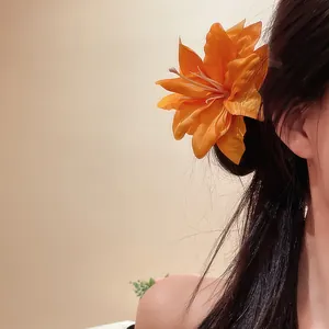 Detail of a vintage orange lily flower duckbill hair clip for an aesthetic forest look.