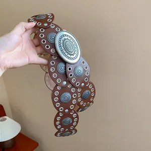 Detail view of a vintage Western-style brown leather belt with metal rivets and studs
