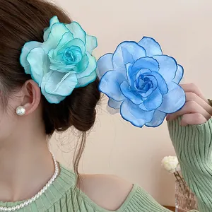 Nahaufnahme von eleganten blauen und mintgrünen Stoffblumen-Haarspangen an einem Model