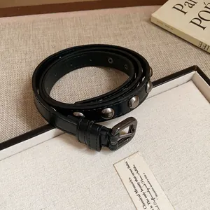 Close-up of black leather belt with silver rivets and metal buckle design