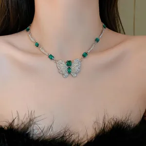 Elegant butterfly necklace featuring green emerald-like stones on a silver chain