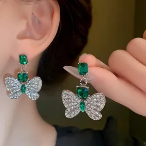 Elegant green crystal butterfly stud earrings with silver-toned rhinestone wings
