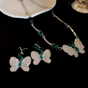 Close-up of emerald green butterfly necklace and earrings set with brilliant crystals