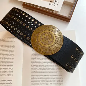 Vintage wide black leather belt with ornate gold circular buckle and metal rivets