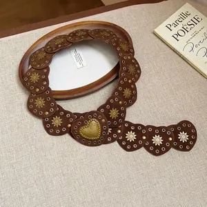 Detail of heart-shaped leather waist chain with vintage sun-patterned rivets.