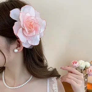 Elegante Nahaufnahme einer großen rosa Stoffrose Haarklammer, die von einem Model getragen wird