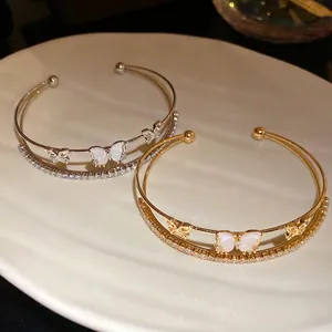 Elegante brazalete de mariposa de doble capa con circonitas sobre un plato de cerámica blanca