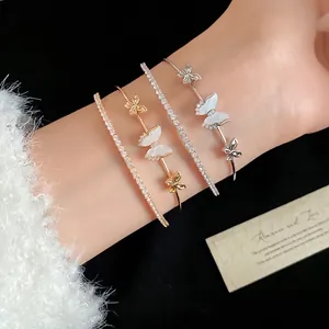 Elegantes brazaletes de mariposa de circonio en capas para un look de moda de lujo.